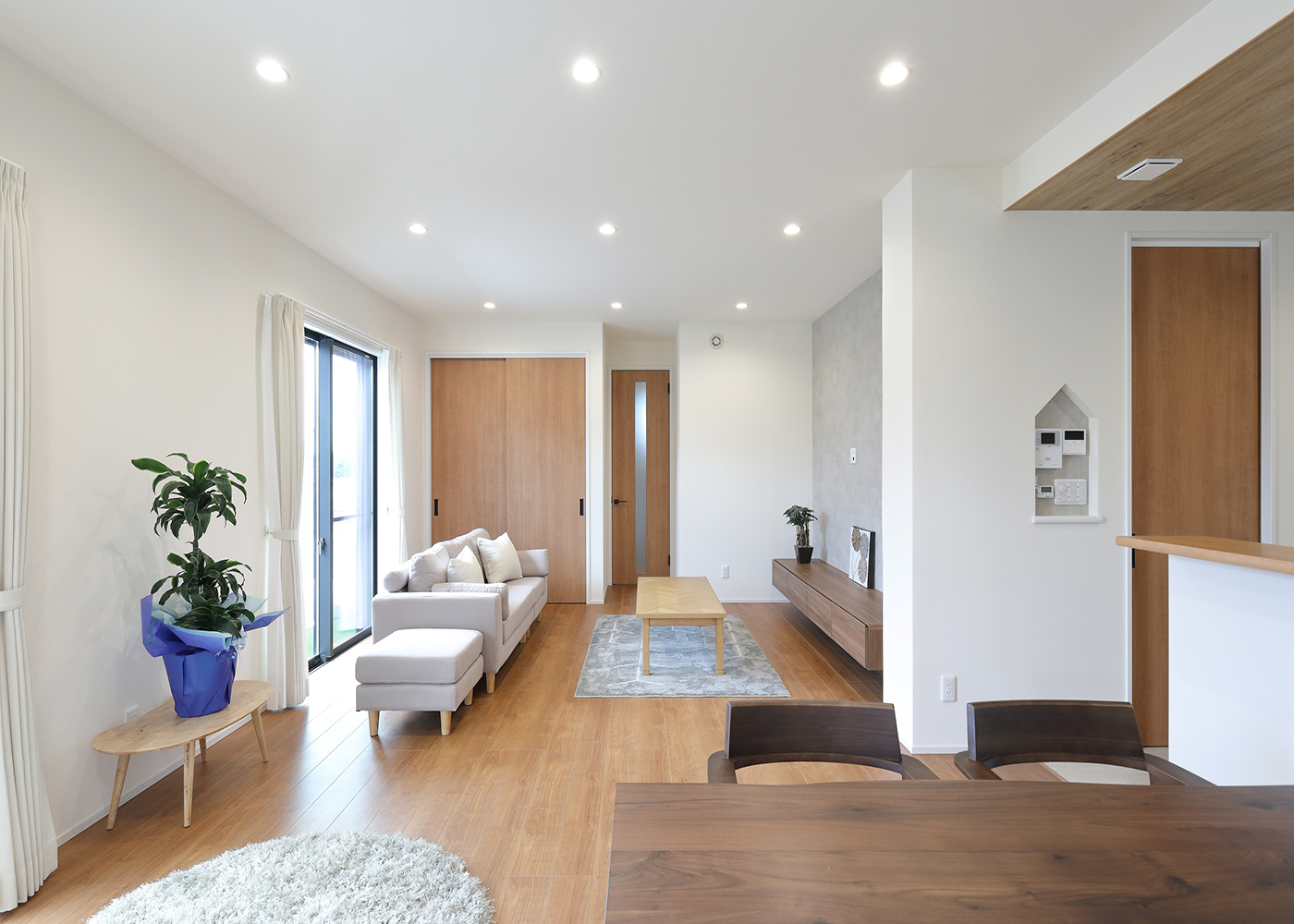 丸昇彦坂建設【子育て、収納力、間取り】建物の南側に設けた広やかなLDK。白と木目を基調にしたベーシックなインテリアコーディネートで、落ち着きのある空間を演出