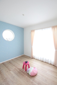 明るい日差しが差し込む子ども部屋。丸窓が可愛らしいアクセントになっている。