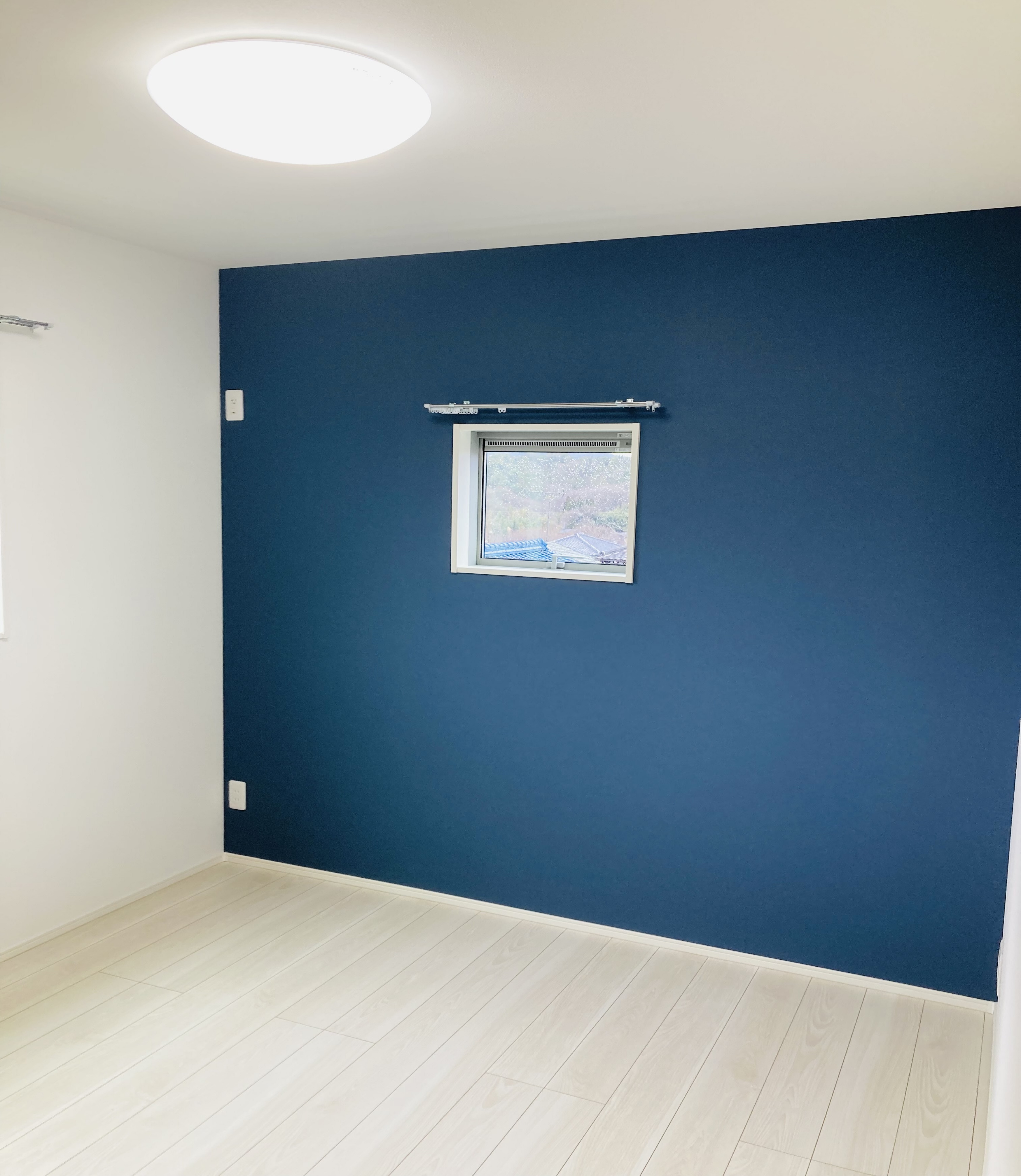 沢田建設｜明るくシンプルな主寝室。壁面には青色がアクセントとして使われ、落ち着いた雰囲気を演出している。使い勝手の良い空間設計。