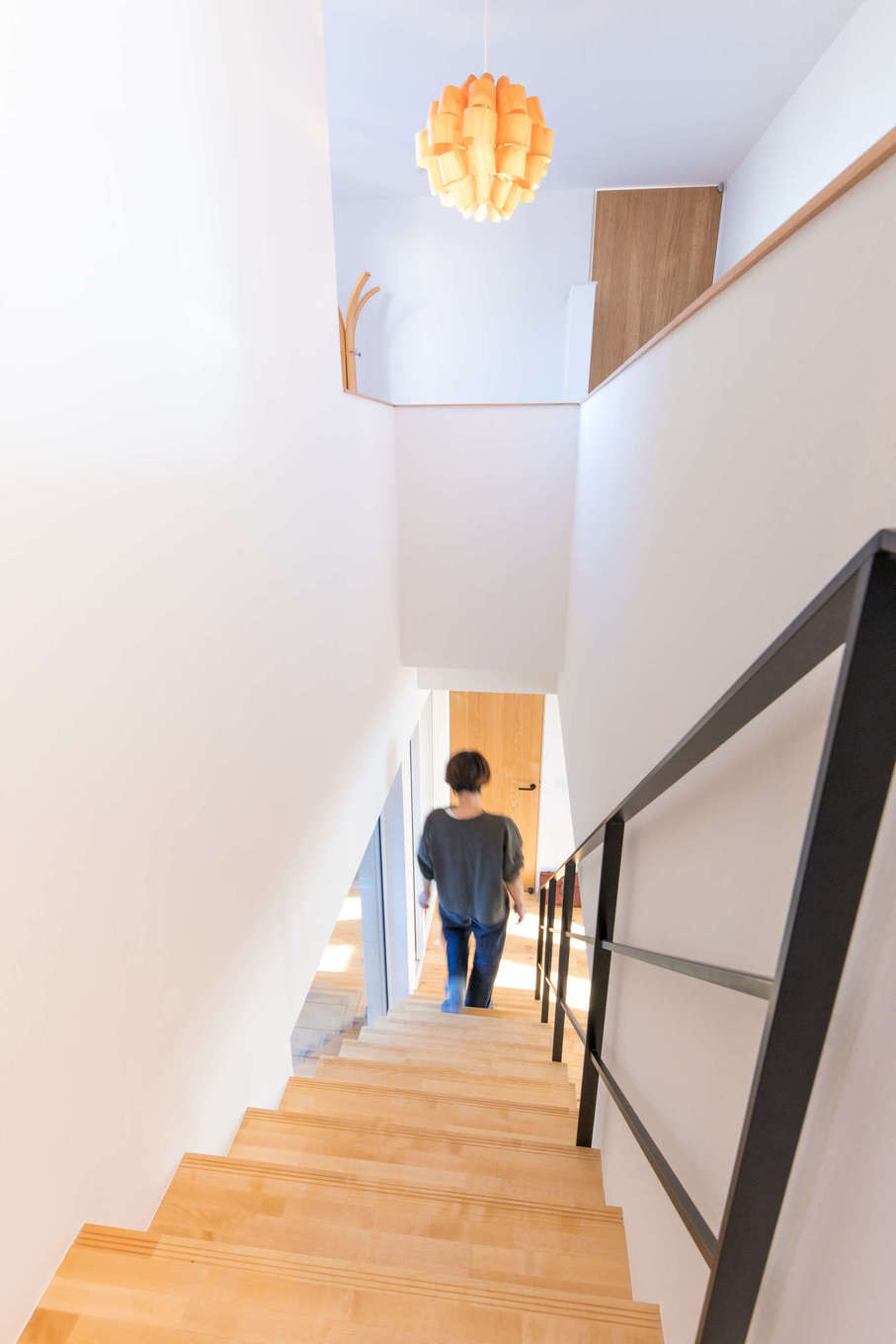 DAIBA HOME【子育て】以前の住まいから使っていたという照明がアイアンのスケルトン階段によく似合う。階段上のホールには、奥さまと娘さんが使うピアノを置く予定