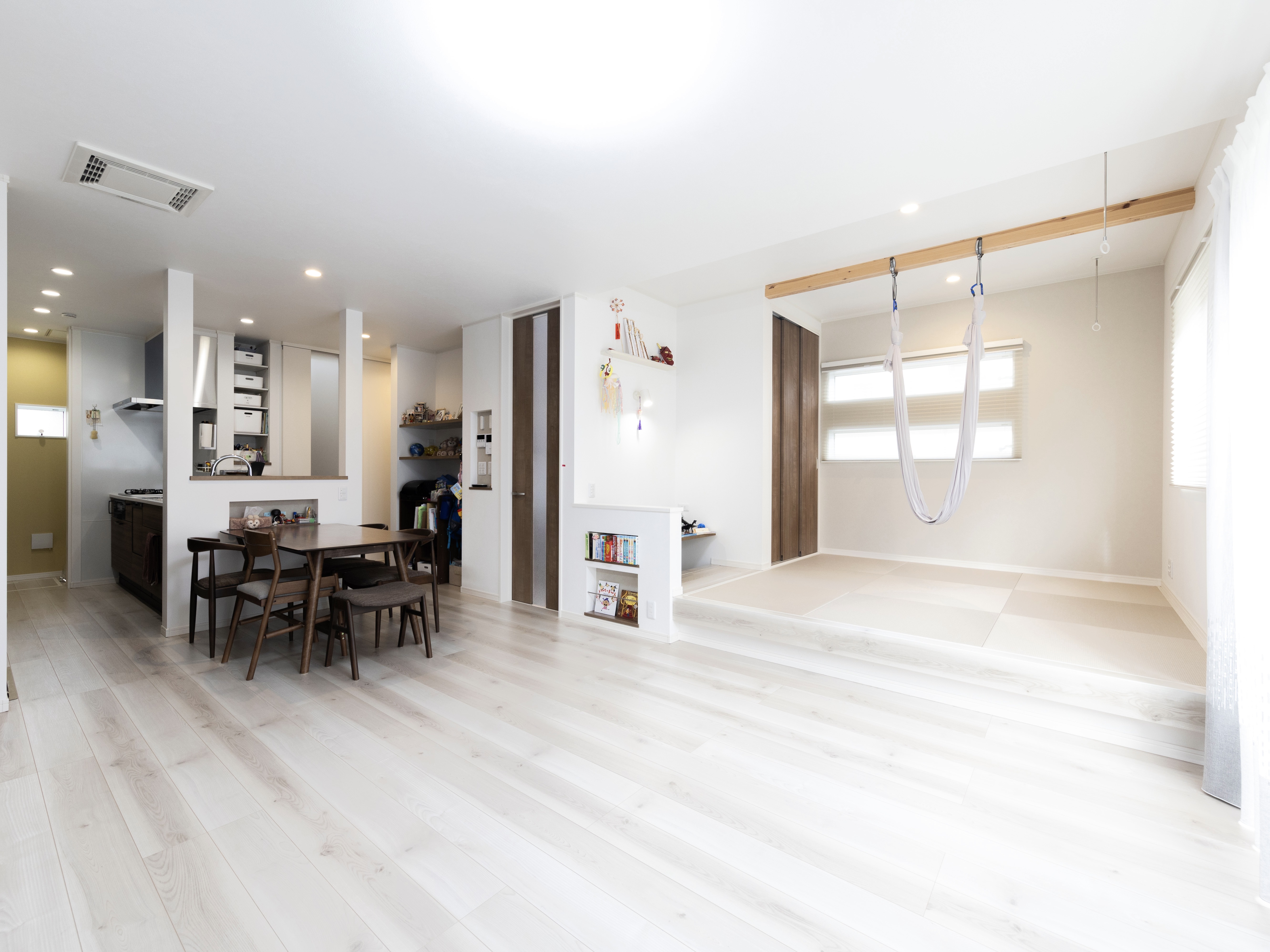 エスホーム｜リビングを広く使うためと掃除の手間を考え、ソファーは置かずに和室の小上がりを椅子がわりに使う。和室はエアリアルヨガ用のハンモックを吊るせるように、天井を高くした。