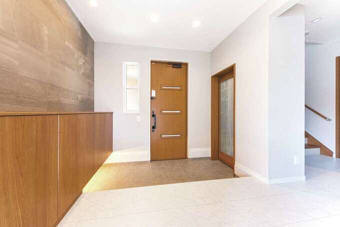 家族が並んで靴を履けるほど広い玄関。大理石調のフロアで華やかな空間に