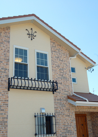 アイアンの飾りやフラワーボックス、格子が特徴的な洋風の外観