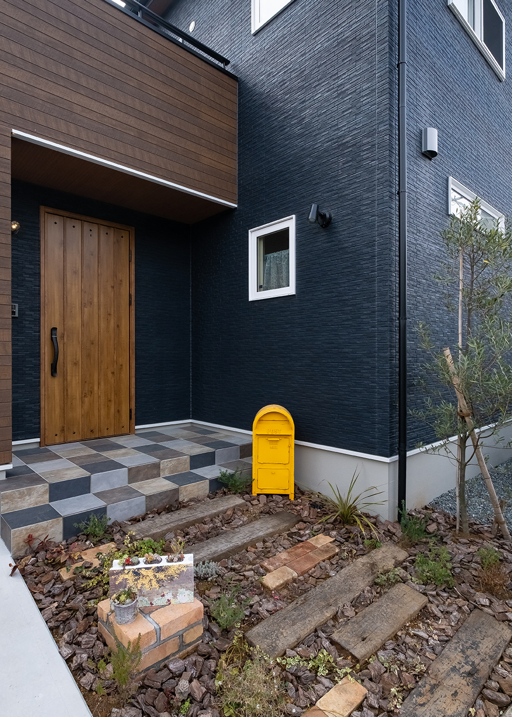 イデキョウホーム【デザイン住宅、省エネ、間取り】黄色いポストがネイビーの外観と対照的