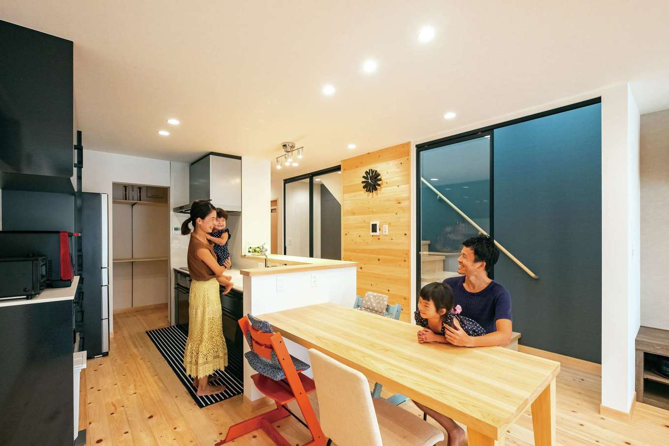 靖和工務店【子育て、狭小住宅、間取り】階段室は圧迫感がないガラスの引き戸に。アイアンフレームと階段室のクロスがアクセント。壁は床と同じひのき張り