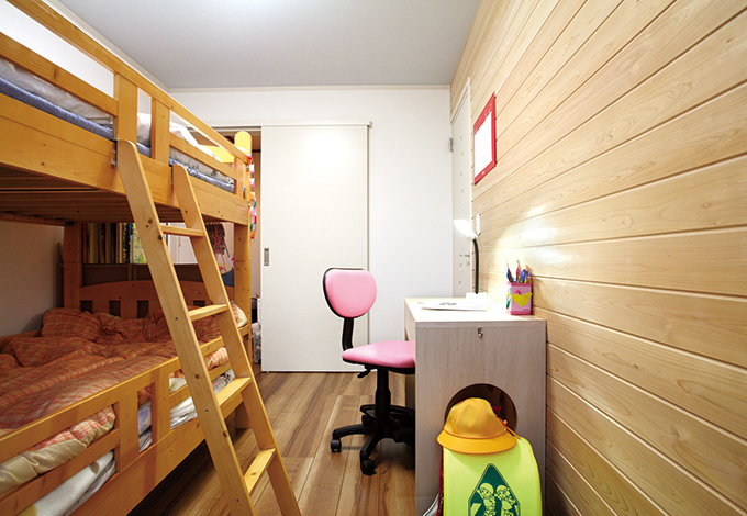 アクセントウォールに杉の無垢板を張り天井は空色にして、のびやかでナチュラルな雰囲気に仕上げた子ども部屋