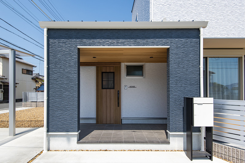トキワハウス デザイン アンド ビルド（常盤工業）｜木目と石材を組み合わせたスタイリッシュな玄関。陽射しが差し込む開放的な空間で、訪れる人を迎え入れる