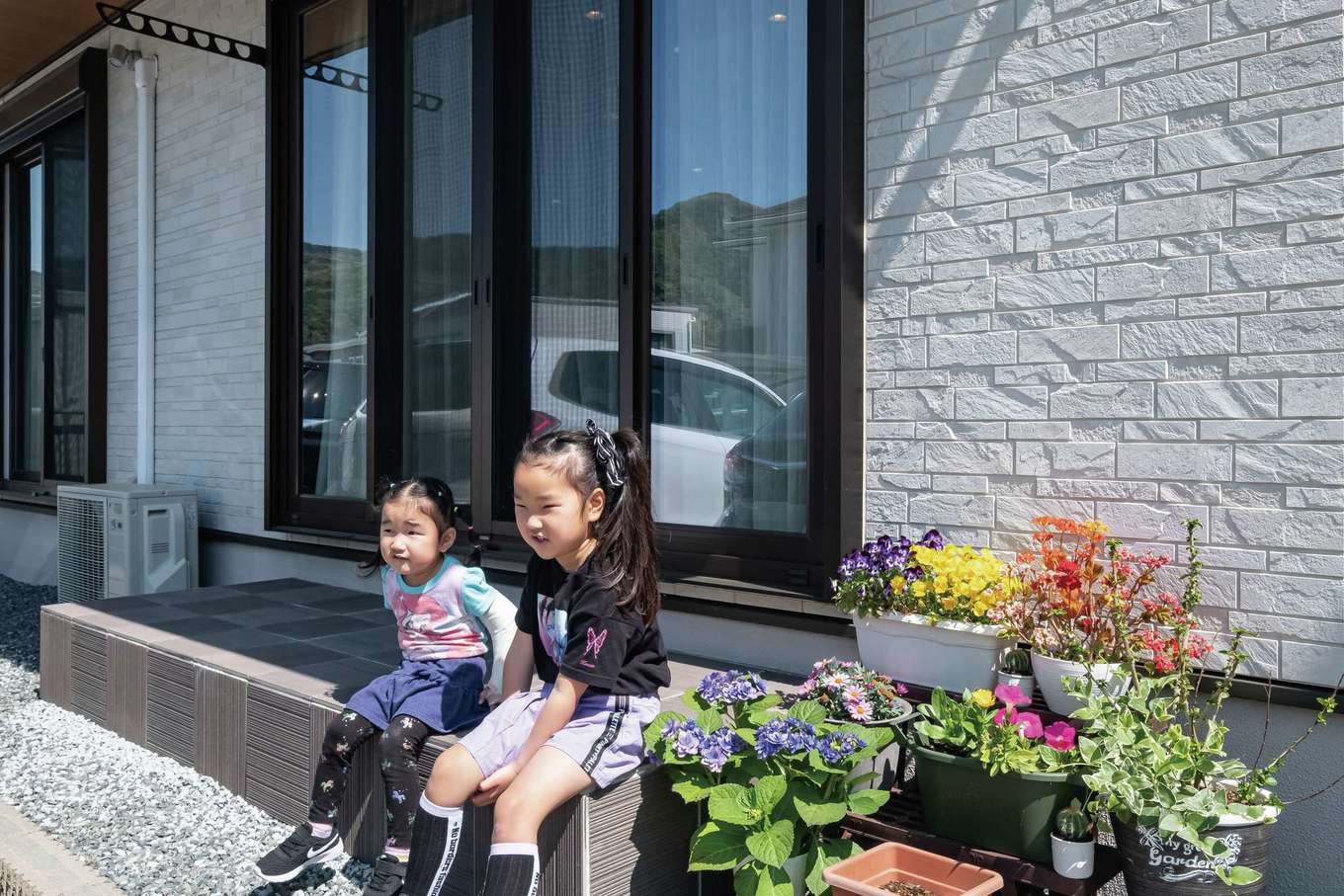 イーホーム【子育て、省エネ、間取り】テラスでくつろぐ仲良し姉妹。BBQや子どもプールを楽しむことも