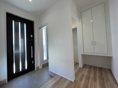 明るく開放感のある玄関ホール。シンプルなデザインの収納が設置され、使い勝手の良さが際立つ空間です。