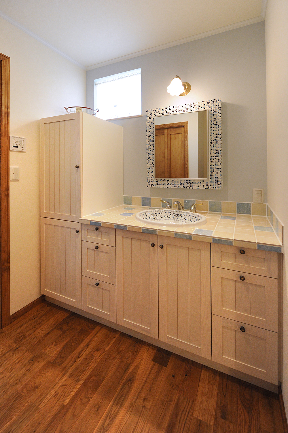 アイディートゥー 一級建築士事務所【デザイン住宅、輸入住宅、間取り】奥さまお気に入りの輸入洗面化粧台。木、タイル、陶器、クロスといった素材感を楽しみながら、洗顔やメイクができる