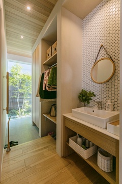 自然光が差し込む洗面スペース。白を基調としたシンプルなデザインで、落ち着いた雰囲気が漂う