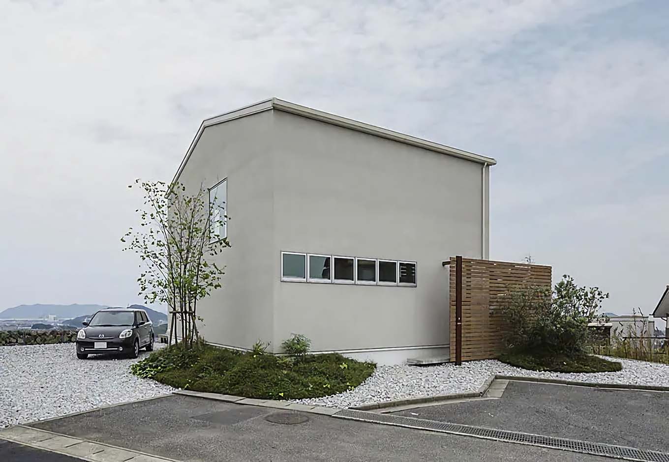 積水ハウス【デザイン住宅、間取り】シンプルでスタイリッシュな外観が目を引く、「サカノウエノシロイイエ」。木製フェンスと植栽が白い外壁に映える
