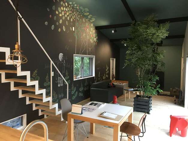 マットな質感の黒とグリーンの色使いに癒やされる室内。黒板クロスのイラストは、窓の外の景色と連動するように描かれている