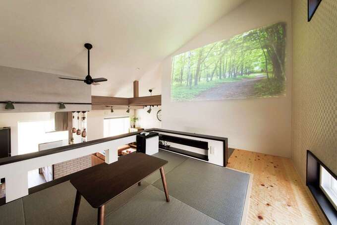 スキップフロアはご主人の漫画ルーム兼シアタールーム。白い壁面をスクリーンに利用。畳敷きなのでゆったり寛げる