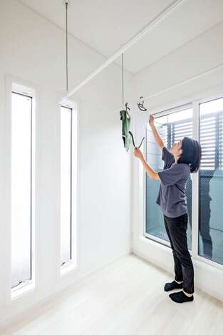 ランドリールームは光と風が入る建物の東側に配置。外から洗濯物が見えないよう外壁に格子を付けた