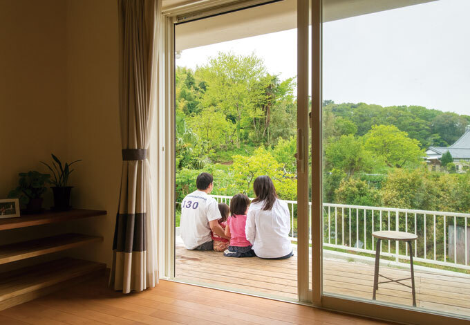 リビングを囲むように作られたウッドデッキ。お隣の緑を借景に。清々しい景色が広がる