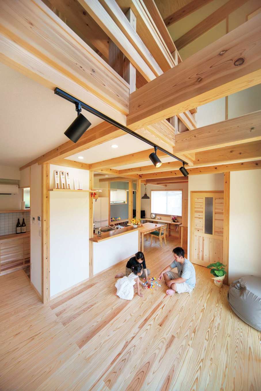 アクトホーム【子育て、自然素材、省エネ】吹き抜けのある明るい大空間リビングと、ダイニングテーブルを一体化した回れるキッチンはTさんの憧れ。自然素材に包まれて、快適な暮らしを叶えている