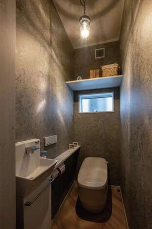 シックな雰囲気にまとめられた1階トイレ。照明はおすすめの中からじっくりと吟味