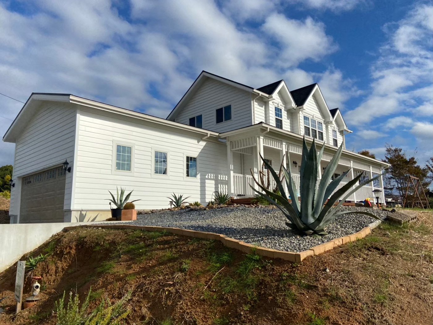 ジェネラルアメリカンホーム【デザイン住宅、輸入住宅、ガレージ】愛車を守るインナーガレージを完備。白いラップサイディングの外観は、アメリカ住宅のベーシックなデザインだ