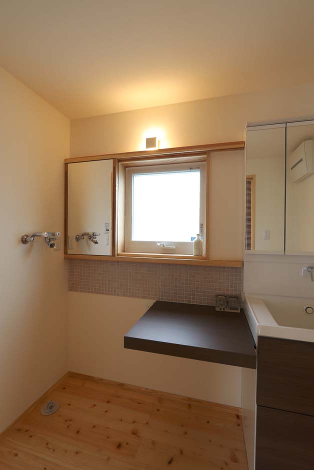 エコフィールド【自然素材、省エネ、間取り】洗面室横は洗濯機置き場。洗剤などを置いたり、作業台にも使ったりと多目的に使える小さなカウンターを設置