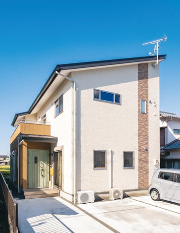 片流れの屋根ですっきりと整えられた外観。レンガ調のラインや淡いグリーンの玄関ドアでナチュラルな印象