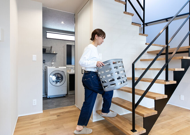 リビング階段は、洗面脱衣所からも近い位置にすることで、ランドリールームまでの動線を短縮。ナチュラルな空間にアイアンのブラックがアクセントを添える