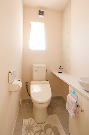 大き めのカウンターと洗面ボウルも白で統一 して、清潔感溢れるトイレ。壁には調湿・ 消臭効果があるエコカラットを使用