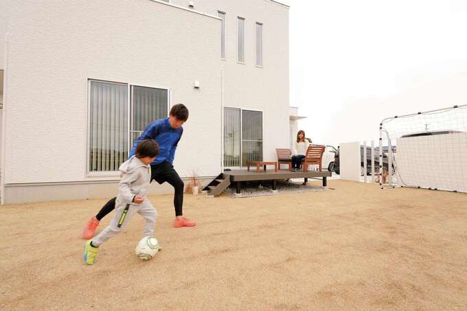 高校サッカーで全国大会への出場経験のあるご主人が、息子さんにサッカーを教える。リビングに繋がるウッドデッキに屋外用ソファを備え、奥さまが見守る姿も