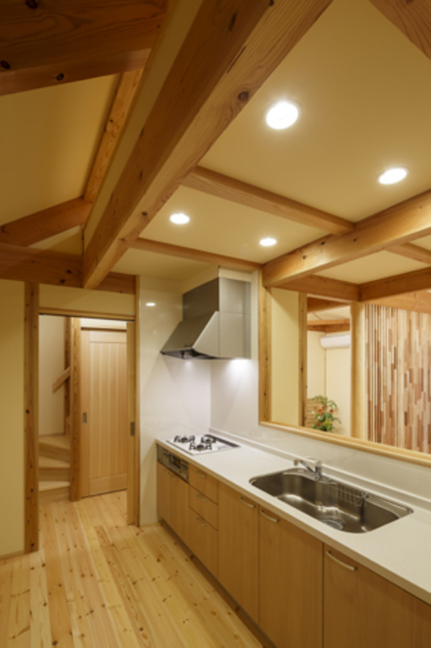 吊り戸棚を廃し、すっきり広々とした対面キッチン。「女房の喜ぶ顔が見たくてね」と、ご主人はいつも釣ってきた魚を自分でおろして皿に盛りつける。ダウンライトのやさしい光が料理をよりおいしく見せる