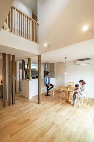 低燃費住宅静岡® TK武田建築｜吹抜けのLDK。高い断熱・気密性能とトリプルサッシによって、大通りの車の騒音が全く聞こえない。クルミの床と円卓テーブルがベストマッチ