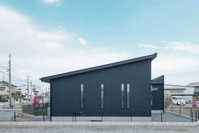 窓のラインが美しい東側から見た外観。片流れの屋根に搭載した13.6kWの太陽光発電は初期費用0円で、光熱費を抑える低燃費な暮らしを叶えた。ご主人のこだわりで玄関ポーチに焼杉の板を採用した