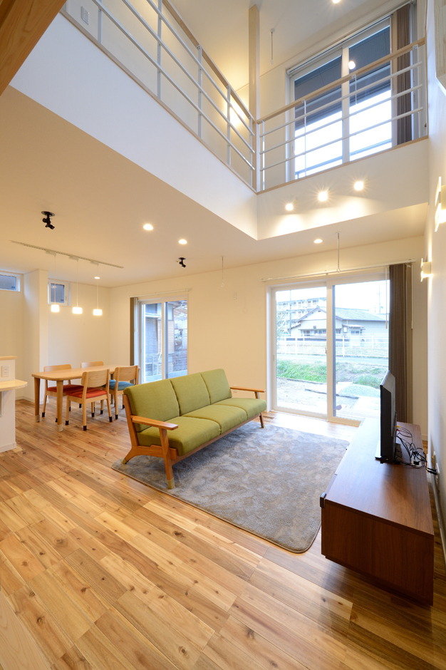 ダイナミックな吹抜けのリビング。ハイサイドサッシと南面の開口部からたっぷりの自然光が射し込み、開放感抜群。肌触りのいい床は無垢のアカシアを使用。冬でも素足で過ごせるほど暖かい