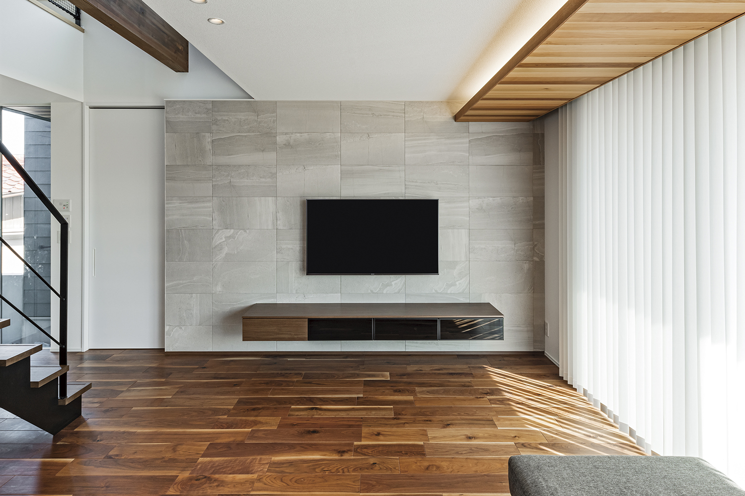 アールギャラリー（アールプランナー）【デザイン住宅、子育て、建築家】リビングのテレビ背⾯壁にはアクセントタイルを採⽤。⼀枚⼀枚表情の違うタイルを、職⼈が丹念に貼り分けてできたTさん邸にしかない空間。独特の雰囲気を醸し出す壁がTさんのお気に⼊りなのだそう
