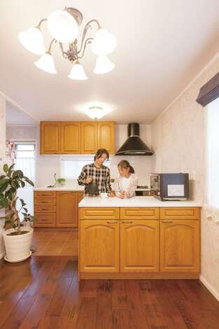 カナダ製「メリットキッチン」の木目の美しさと温かみにひと目惚れ。独立した作業台が便利で収納力も抜群。タイル張りにした床は掃除もしやすい。家を建ててから長女がお菓子づくりにはまっているそう