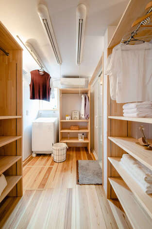 玄関とキッチンの間に設けたランドリー＆脱衣室。造作の収納棚、3連の部屋干しポールを備え、子育て夫婦も楽々。洗面コーナーと分けたことで、より使いやすい