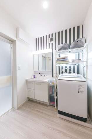 ストライプの壁紙が目を引くおしゃれな洗面所