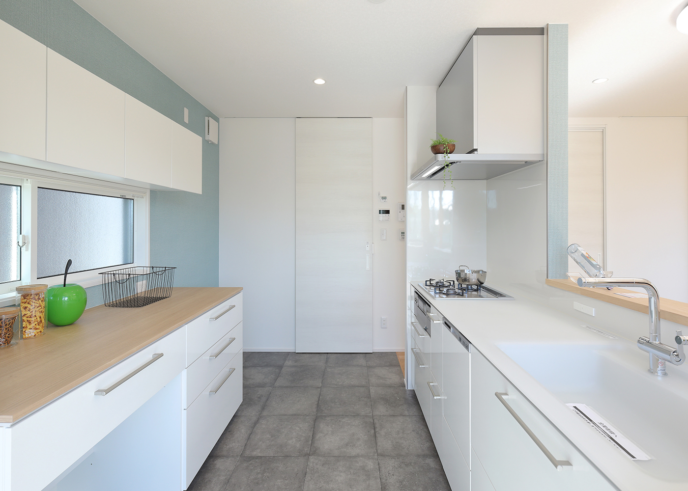 丸昇彦坂建設【デザイン住宅、趣味、間取り】光が入り開放感あふれる。キッチン背面のアクセントクロスのブルーがより爽やかな印象を与える