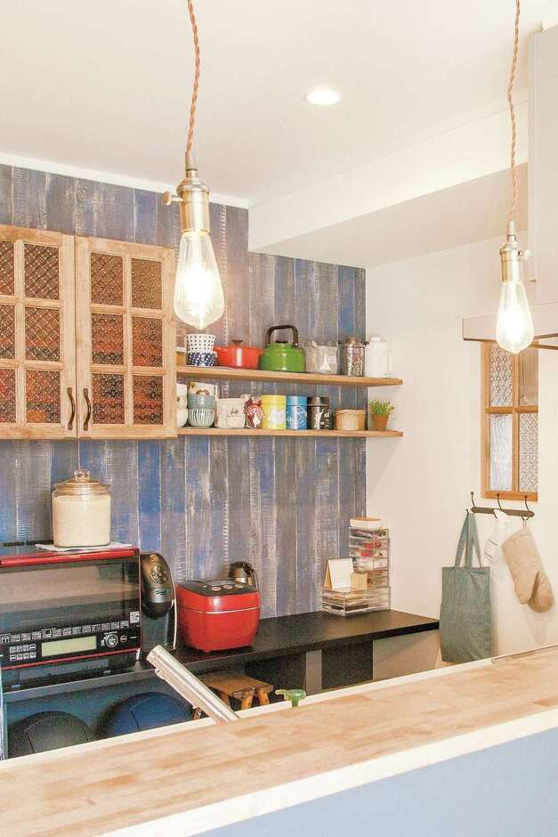 機能性と好みのテイストが融合したキッチンは、奥さまがほっとできる場所。造作のカップボードはガラスや取っ手まで吟味。分離させたパントリーがスッキリに貢献