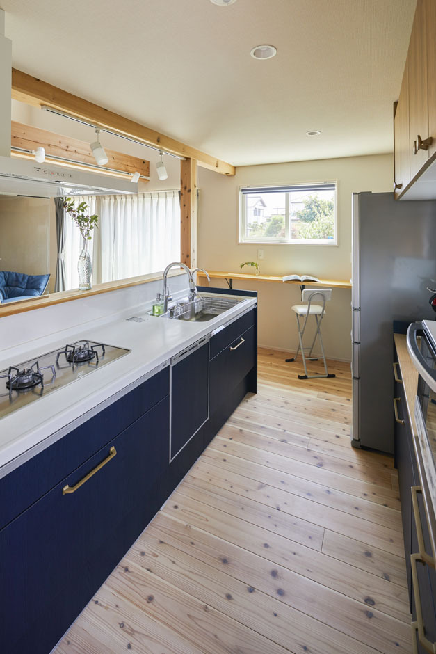 奥さまの大好きなネイビーをキッチンの面材に使い、差し色に。玄関ドアの回りの鎧張りの杉板にも同系色を使用
