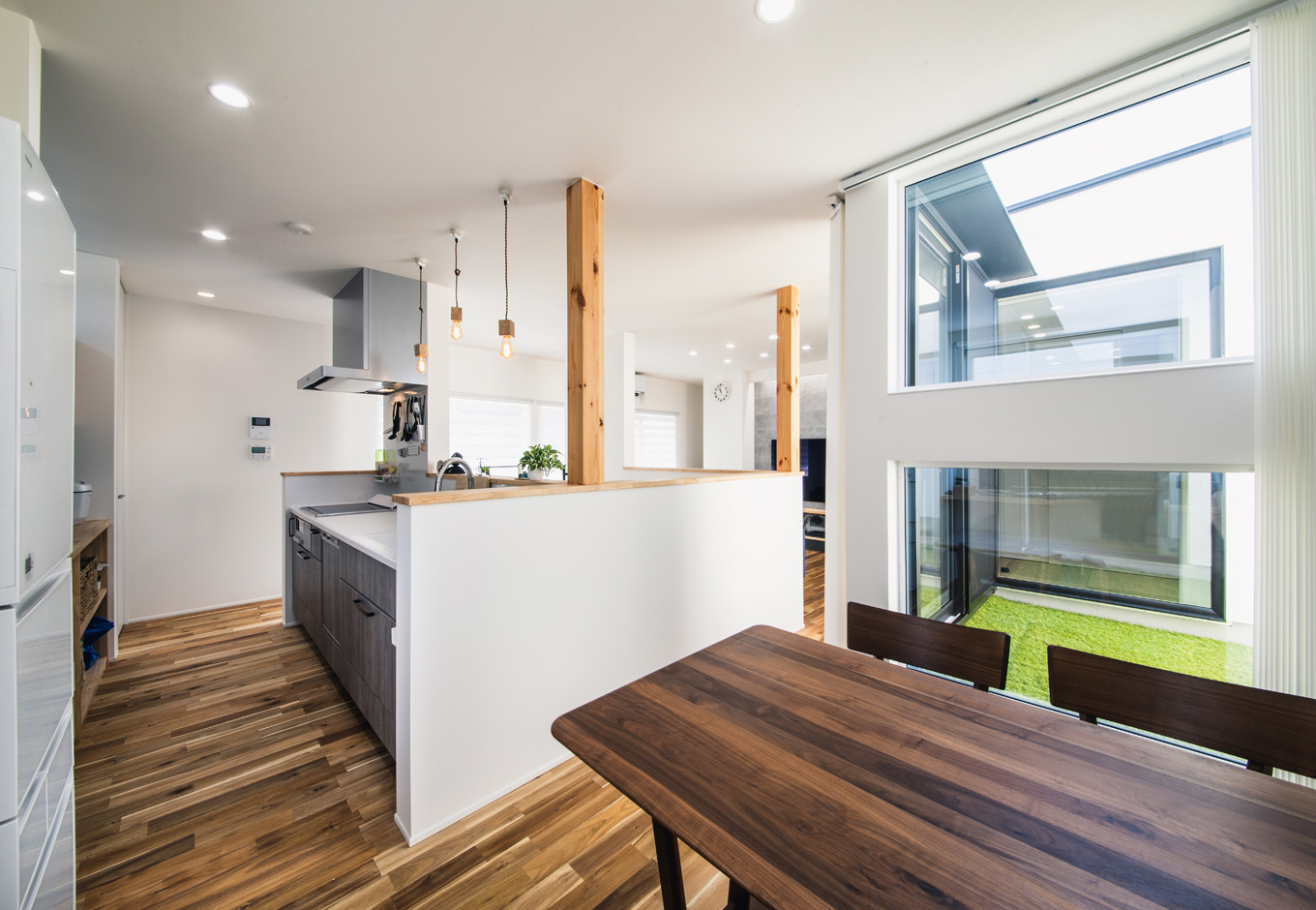 SEIEN ARCHITECT【趣味、建築家、1000万円台】アイランドキッチンの横にダイニング、階段を挟んだ正面にリビングを配置。回遊式の動線によって、リビングとダイニングのどちらにも食べ物や飲み物をラクに運ぶことができる