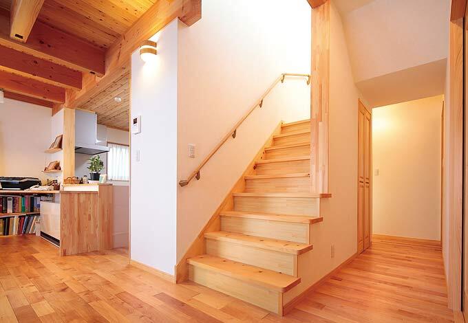 まさに家の中心にあるリ ビング階段。キッチン側か ら階段後ろへと回遊でき るので、慌ただしい朝でも 家族が楽に行き交え、ま た、来客時には“もうひと つの動線”としても便利