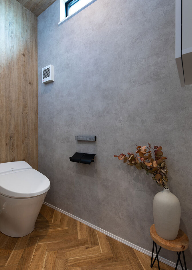 木目とグレーのシックなトイレ。床はヘリンボーン