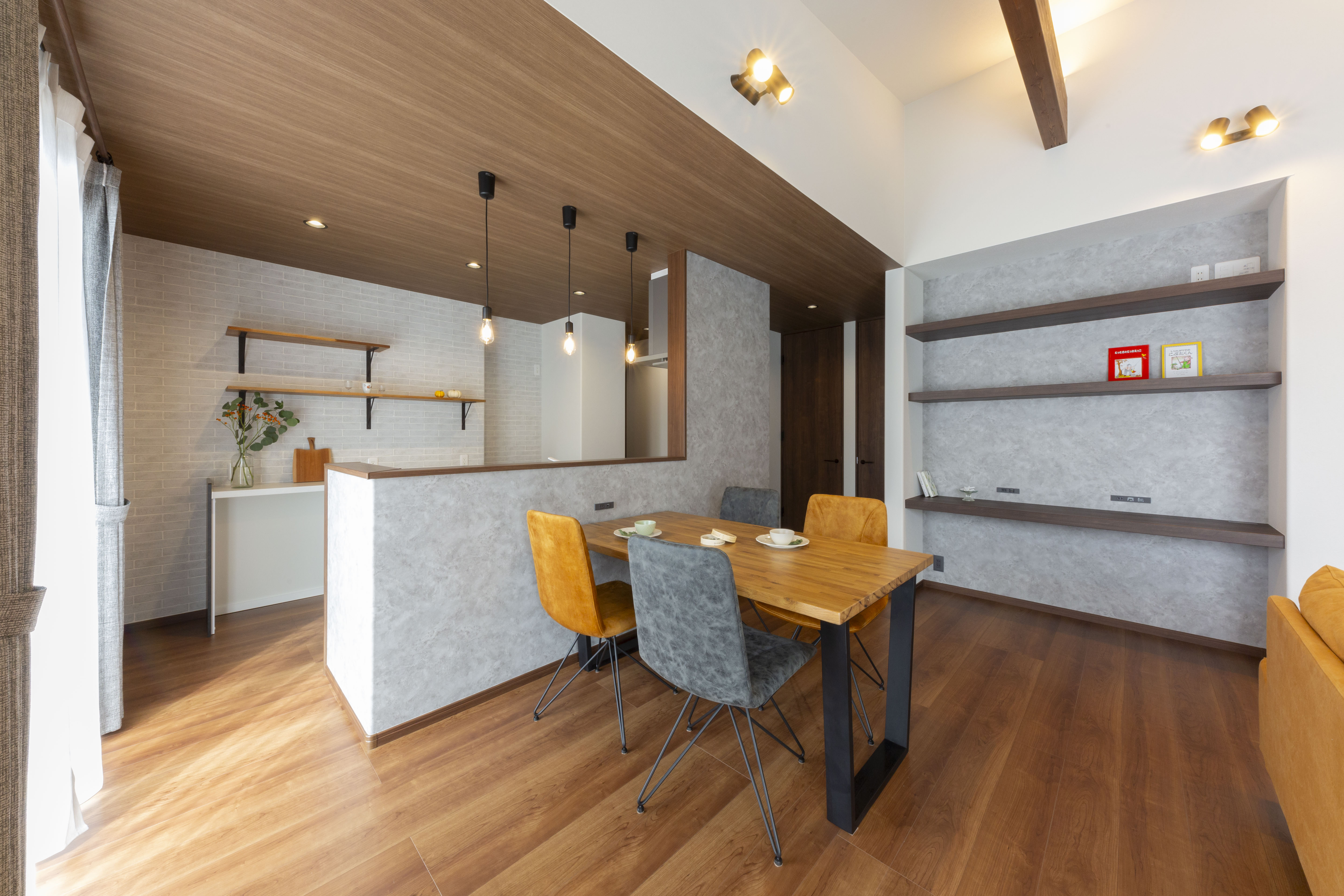 感動ハウス｜木目調のフローリングと天井が温かみを感じさせるダイニングスペース。食卓を囲むシンプルなテーブルセットが、家族団らんの時間を演出する。