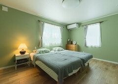 さわやかな若草色のクロスをチョイスした寝室。シンプルで安らげる空間に仕上がっている