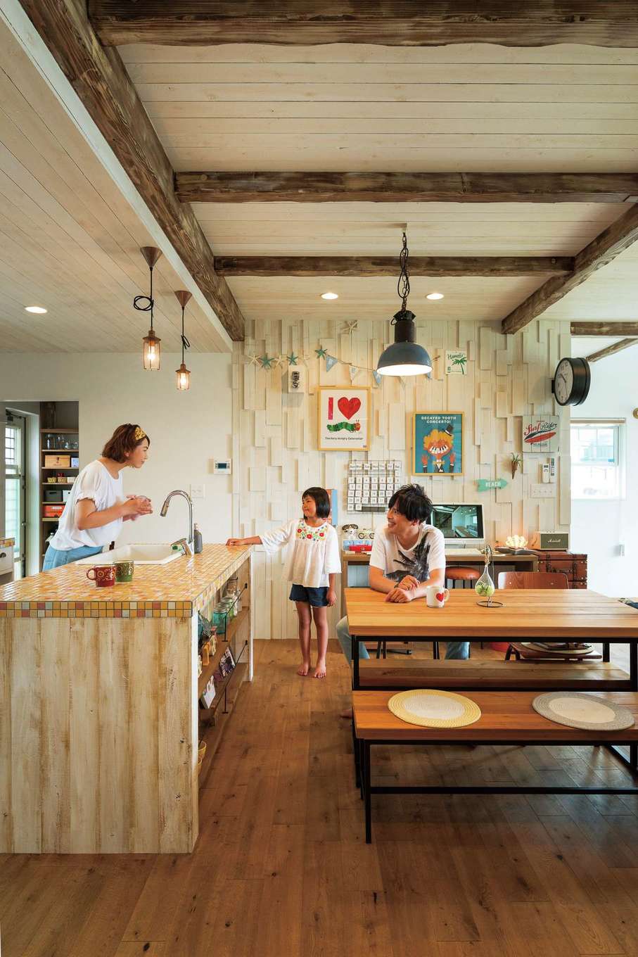 富士ホームズデザイン【デザイン住宅、建築家、インテリア】モザイクタイル貼りのアイランドキッチンも、ダイニングセットも、PCカウンターも、すべて同社のオーダーメイド。正面奥の白いウッドウォールは、木片をランダムに張った凸凹感が個性的。照明やドアベルは本物のアンティーク品