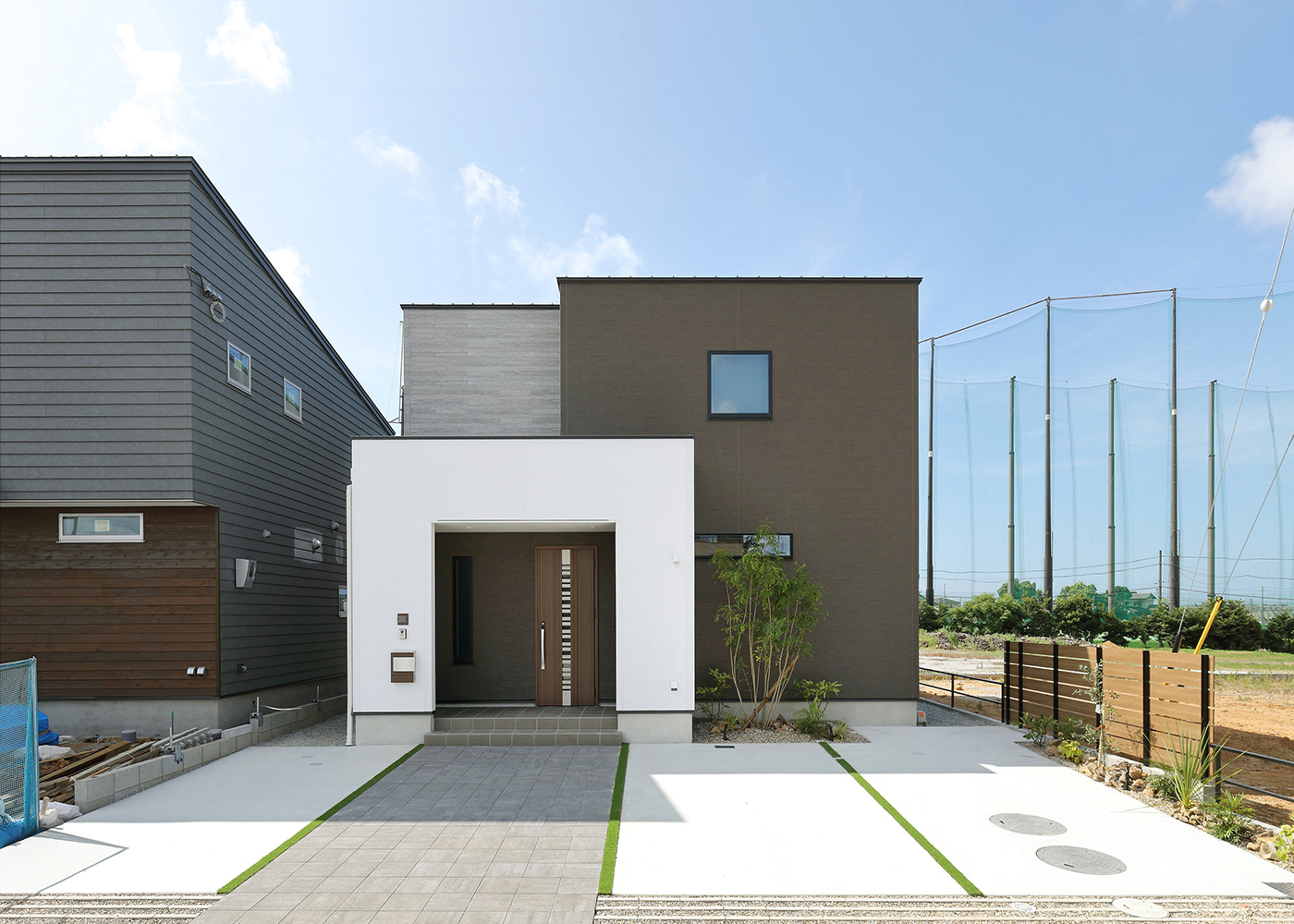 丸昇彦坂建設【デザイン住宅、収納力、間取り】色の異なる四角い箱を３つ重ねたような、斬新でスタイリッシュな外観。雨よけにもなる玄関ポーチは内側が道路側から見えないようになっており、自転車や子どもの三輪車などを置くこともできる