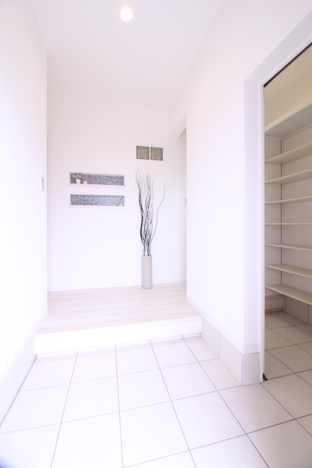 小野田産業～designers house project～｜明るく広々とした玄関ホール。シンプルで洗練されたデザインが心地良さを演出し、棚もあり実用的である。