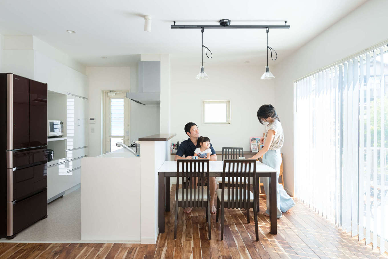 アキヤマ【収納力、省エネ、間取り】大きな窓からたっぷりの光が降り注ぐダイニングキッチン。ダイニングテーブルの後ろにカウンターを造作し、子どものスタディコーナーに。キッチンの床は掃除しやすいよう、クッションフロアを採用。リビングから手元が見えないようにカウンターを高くしたのもこだわり