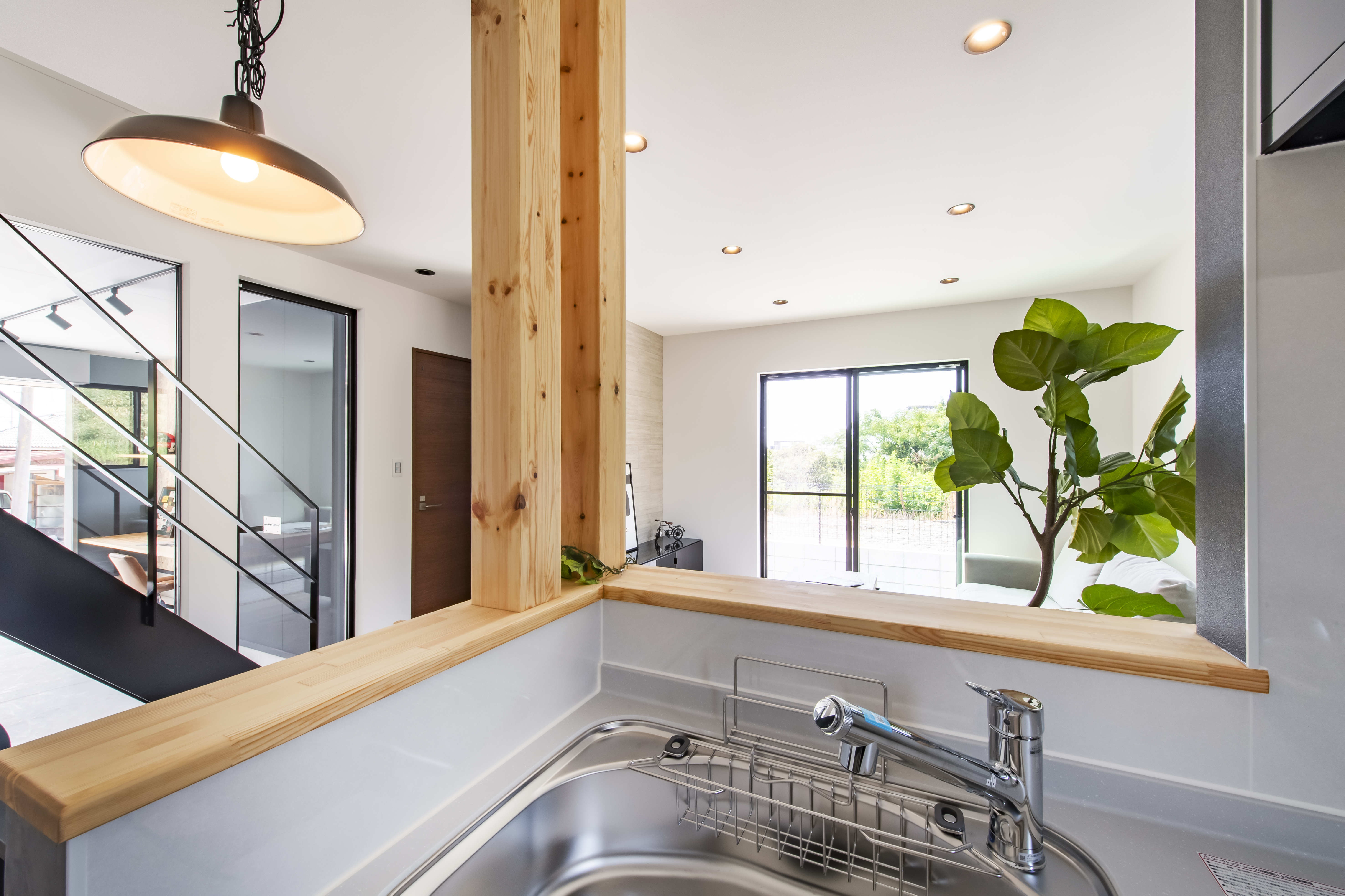 スズイチ｜明るい自然光が差し込むキッチン。木の温もりが感じられ、心地よい空間を演出している。