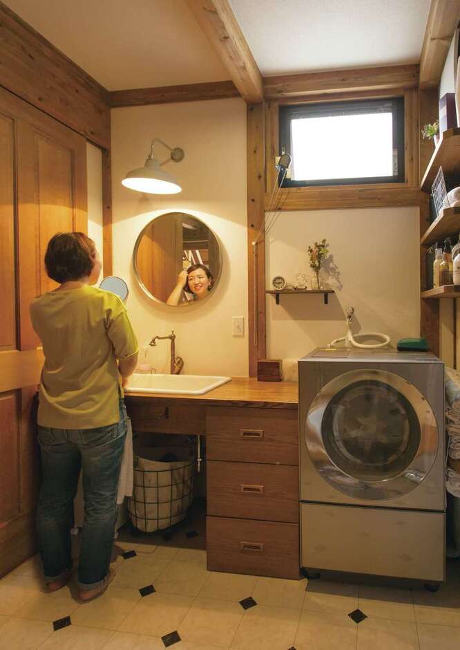 奥さまは独身時代に東京でデザイナーとして働いていただけに、インテリアや色のセンスも抜群。洗濯機のドアと鏡の形を合わせただけでサニタリーの雰囲気がこんなに変わる。木と医療用シンクも程よく調和してステキ